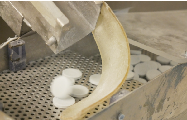 Capsule and tablet press loading and unloading with pneumatic conveyor