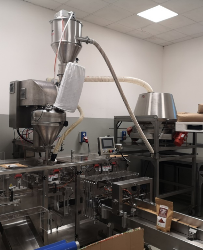 Alimentación de la línea de envasado de productos de confitería con el transportador neumático Delfin